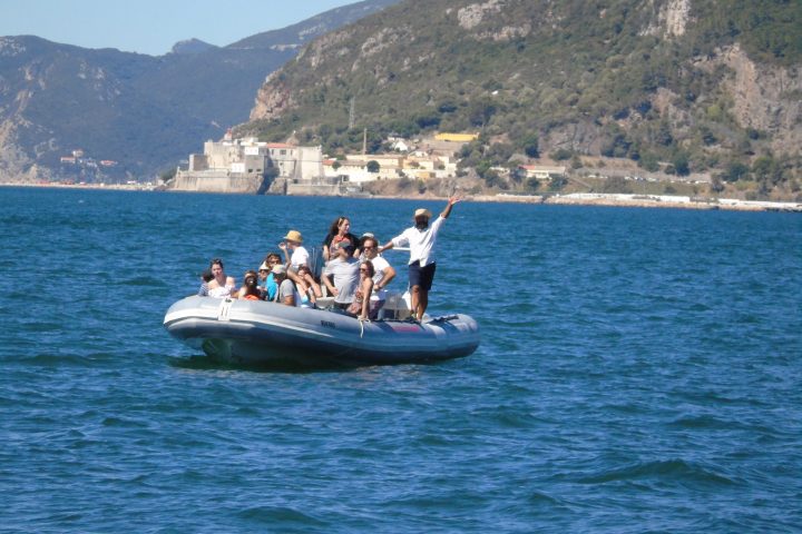 Group of people on an inflatable boat in a scenic coastal area.