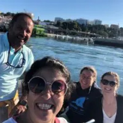 Four people smiling on a boat with a waterfront view.